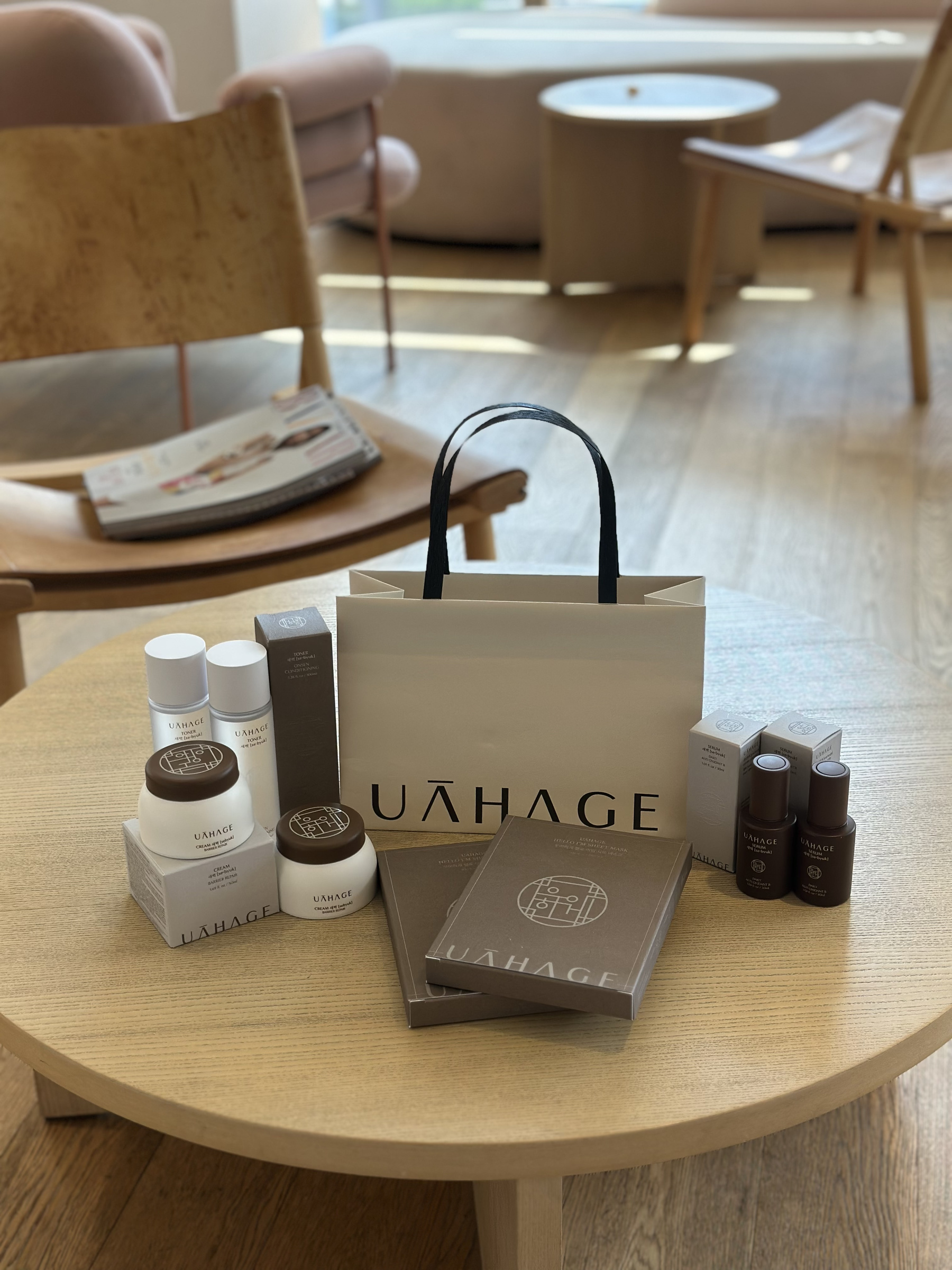 The UAHAGE range on a table: toners, creams, serums and sheet masks with a UAHAGE gift bag